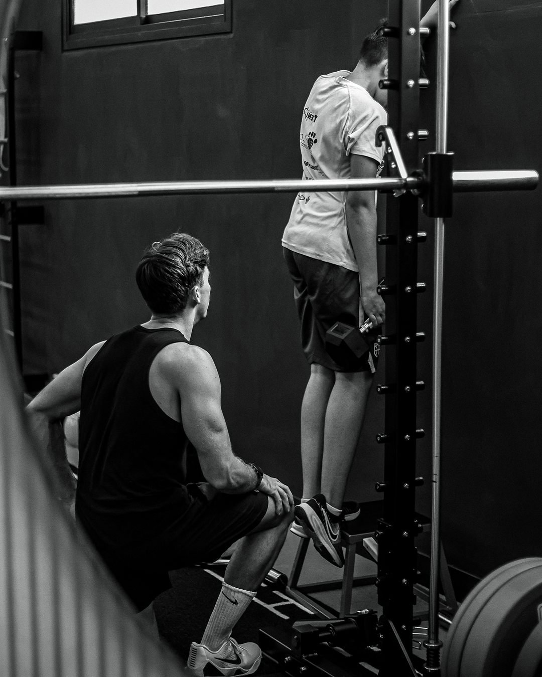 Ascyon Lab: el preparador físico supervisa un ejercicio de un cliente en el gimnasio
